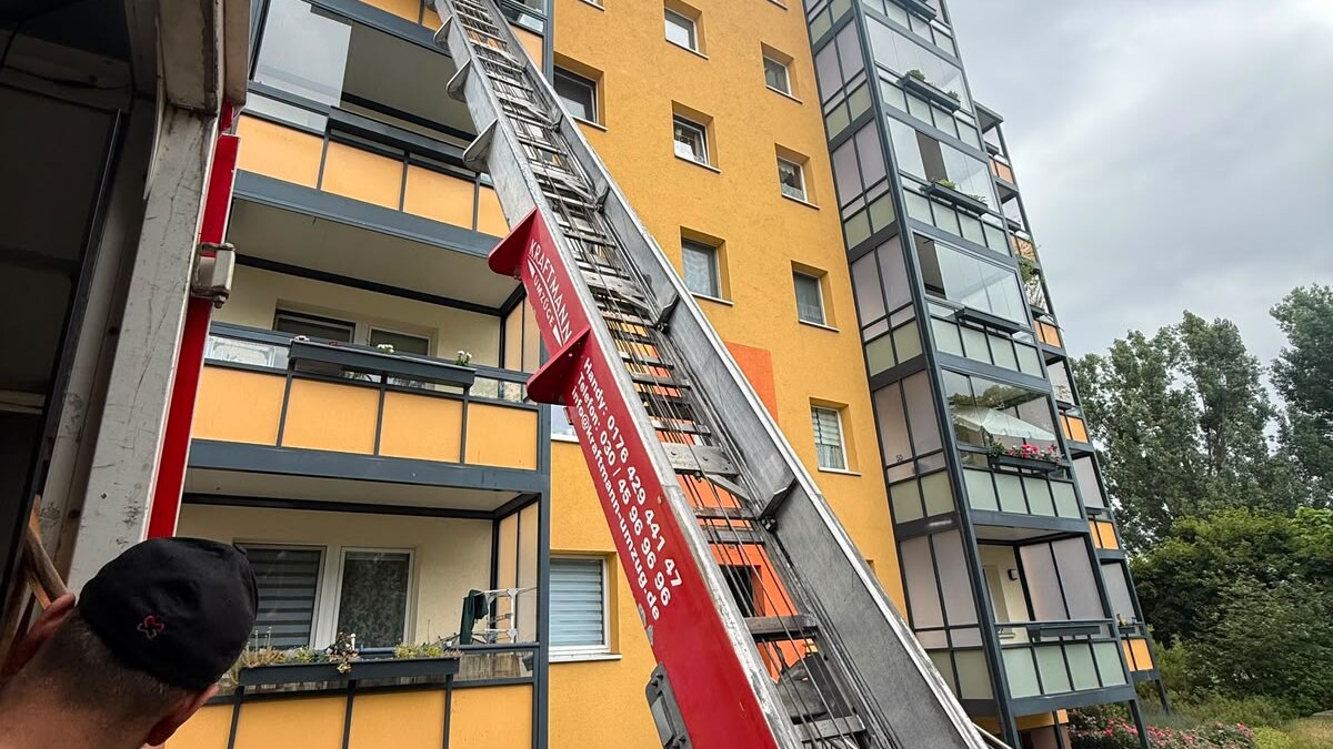 Umzug Altbau Berlin – Möbellift an einer Plattenbaufassade mit Balkonen