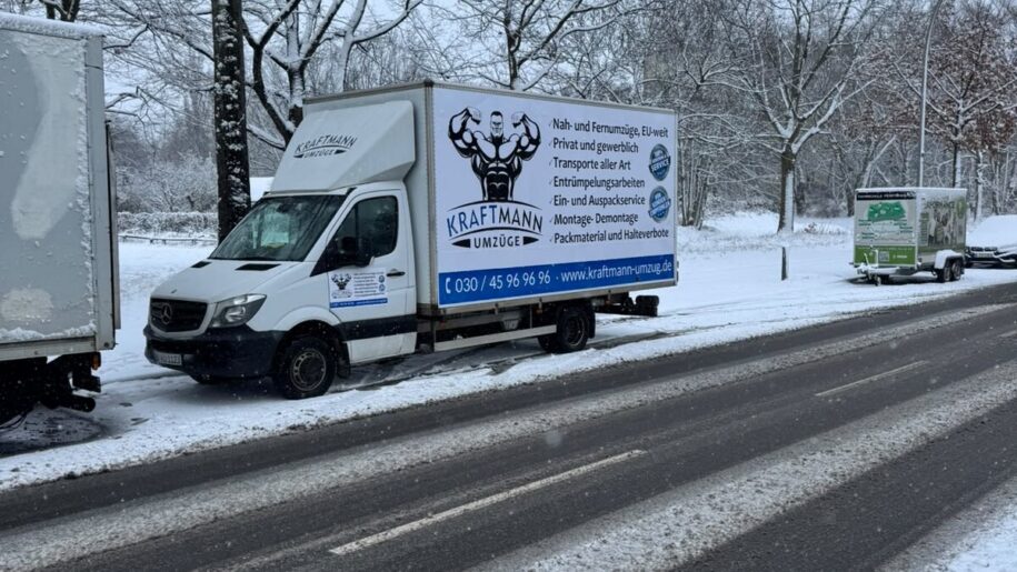 Umzug im Winter – Transporter auf verschneiter Straße