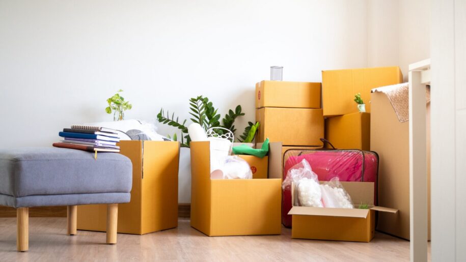 Wohnungssuche Berlin – Kartons und Sessel in neuer Wohnung