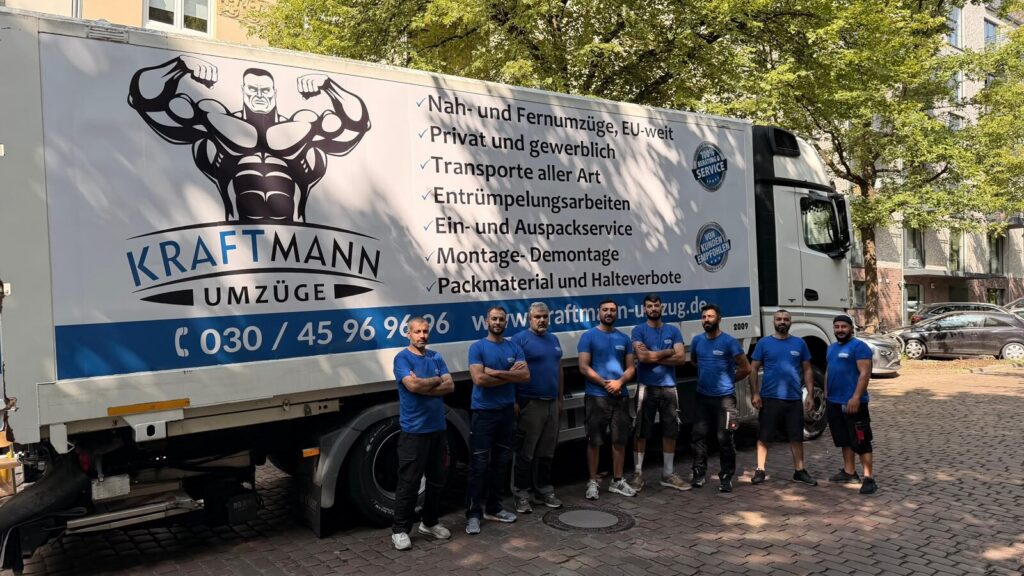 Kraftmann Team mit Möbelwagen vor einem Wohnhaus beim Umzug Potsdam Berlin